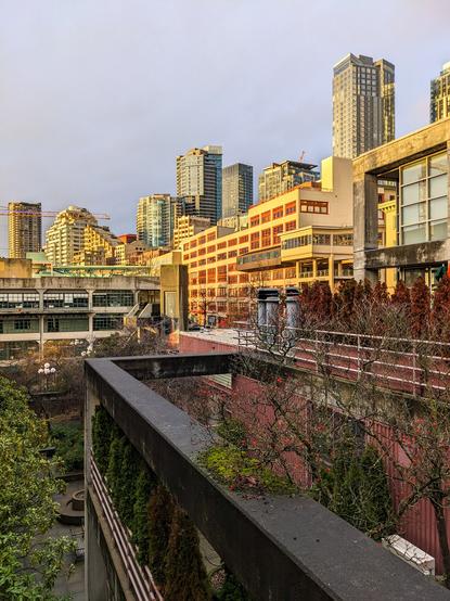 Building courtyard with sunlit city skyline behind it