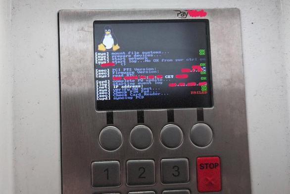 Das Foto zeigt ein Bezahlterminal mit Tastatur und Bildschirm. Auf dem Bildschirm befindet sich links oben der Linux-Pinguin Tux, darunter werden Meldungen des startenden Betriebssystems angezeigt. In der vorletzten Zeile steht Check Card Reader, dahinter FAILED.