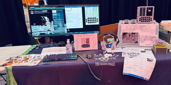 the previous photo cropped to focus on the NASA women of colour poster, the widescreen monitor running the Apollo in Real Time website & a virtual DSKY, 3D-printed DSKY & baby DSKYs, magnetic core memory, & SCE to AUX switch