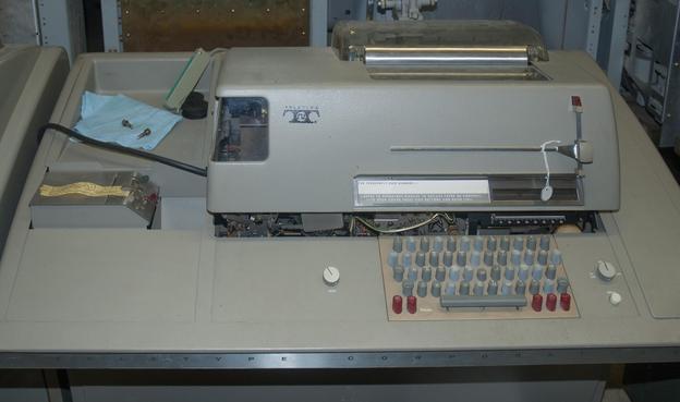 A Teletype Model 33 ASR (automatic send/receive), with paper tape on the left side.