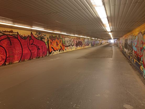 A long underpass at the train station Kelenföld in Budapest, covered with graffity, retro feeling.