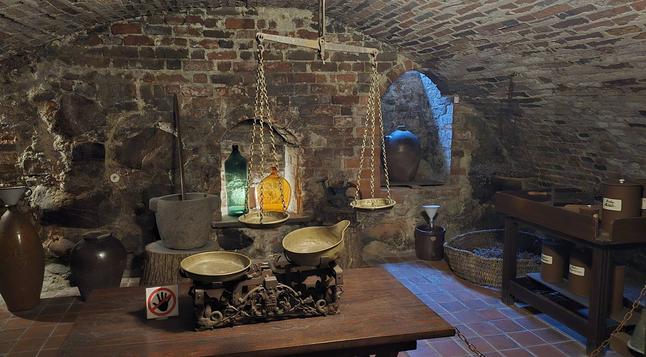 Underground of Museum of the History of Lithuanian Medicine and Pharmacy - storage room and large mechanical scales, different containers in the background used to store ingredients