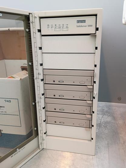 In this photo, the door is open. The drives are a darker beige than the rest of the enclosure, and have tabs at the bottom that make them look hot-swappable? In the top (eighth) bay is a information panel with the DEC logo, the "InfoServer 1000" text, and indicator blinkenlights for "Power OK", "System OK", "Network OK", "Network Activity", "SCSI OK", and "SCSI Activity".

I don't remember seeing network jacks on the back (though I only glanced briefly), but perhaps it acts as a standalone SCSI NAS? Gonna have to research that later...