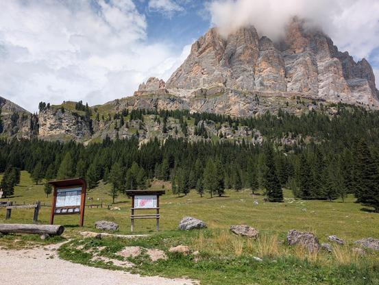 Tofana di Rozzes von der Straße zum Passo Falzarego. An den Gipfeln hängen Wolken fest.