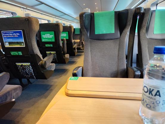 Inside of a train car. Comfortable chairs and good working tables.