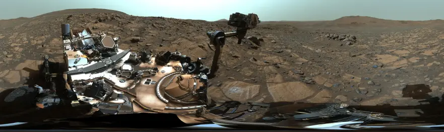 An enhanced color 360° panorama capturing a Martian landscape with the Perseverance rover in the foreground.