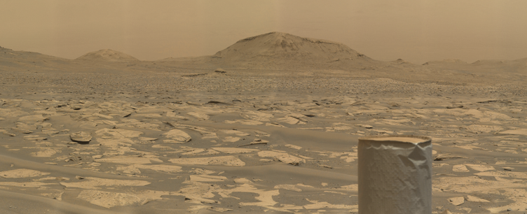 An ochre toned image capturing a Martian landscape, with the UHF antenna of the Mars rover Curiosity in the foreground.