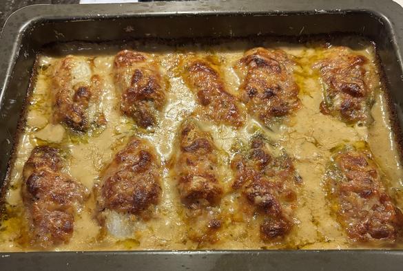 Endive gratin: ten elongated objects with crusty brown tops in a pool of cheese sauce.