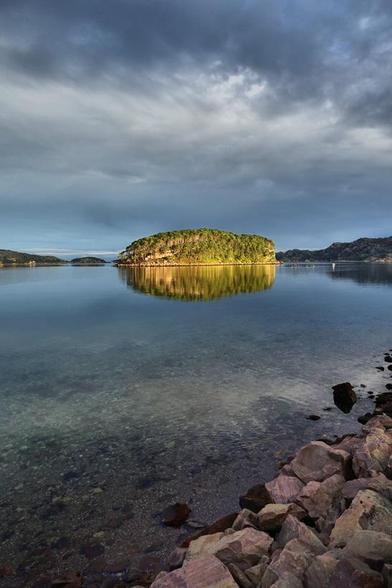 Sunlit island on a dull day.