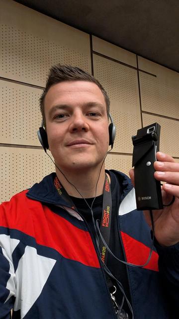 Me wearing headphones connected to a device that looks like a large mp3 player.