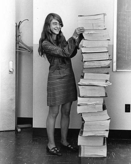A famous black and white photo of Margaret Hamilton, taken in the 1960s. She's checking out a very large printed out stack of her code with a bit of a mischievous smile on her face. And she also has about an inch or so on the stack of code. But yeah, that's how we rolled back then: code and print it, then marker it to find bugs and stuff.