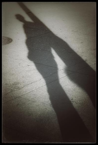 A monogram picture of shadows cast across a sidewalk late in the afternoon outside Pier 35 on the Embarcadero. My husband is leaning against a lamp post. His extra long shadow created as the sun went down caught my eye. Those shadows stretch from lower right to upper left in this photo.

We walked 6 miles that afternoon, as the day went from quite warm to very chilly. Like a tourist in a T-shirt, at 6:30 I almost bought a sweatshirt at Pier 39. After 47 years living in San Francisco, that would have been a first for me.