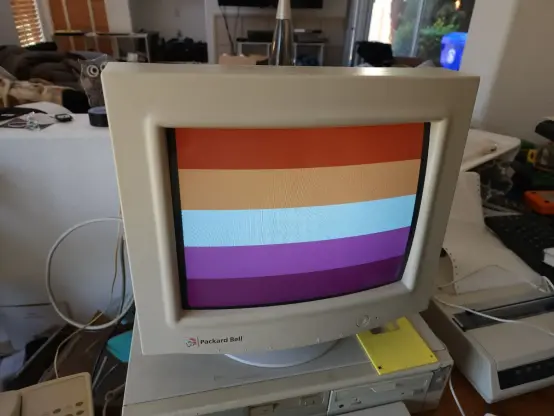 The 5-stripe sunset lesbian pride flag, shown on a beige DOS computer and CRT screen