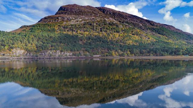 Mountain reflected in a still sea.