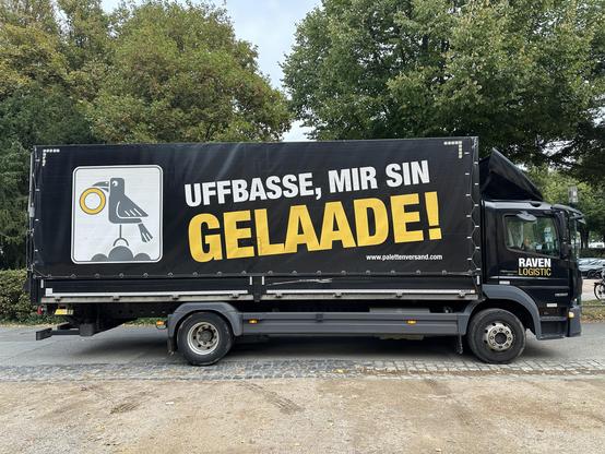 LKW mit Aufschrift "UFFBASSE, MIR SIND GELAADE!"