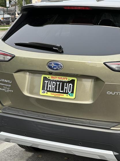 A subaru with a simpsons license plate frame and number THRILHO