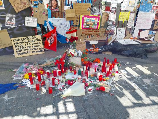 Altar de memoria a MariCarmen, con velas y carteles protesta detrás.