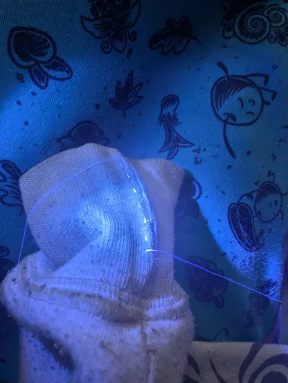Under UV light, the thread glows and it's more visible against the fabric