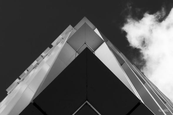 Black-and-white photo looking straight up at the corner of the new SWR building in Mannheim. Diagonal lines lead to the tip.