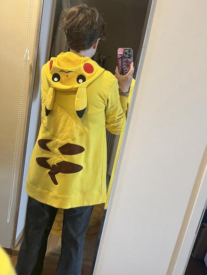A photo of my back in a mirror, showing that I’m wearing a yellow Pokemon pikachuu hoodie.