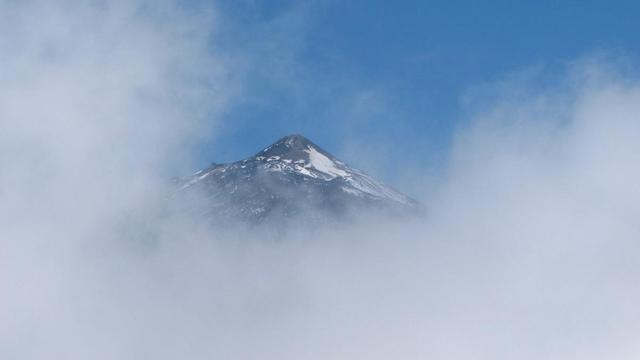 aus der Position zwischen Wolken stehend fotografiert sieht man in der Wolkonlücke den Gipfel des Teide auf Teneriffa