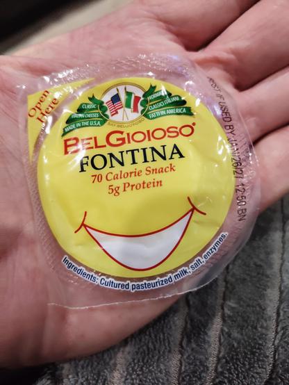 Photo of an individually-wrapped, snack-sized BelGioioso brand piece of Fontina cheese. The printed label reads: "BelGioioso - FONTINA - 70Calorie Snack - 5g Protein" with company logo and a smiley face, on a bright yellow background.