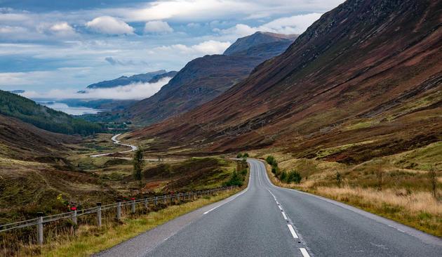 Road through mountains leading down to s loch.