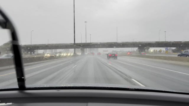 Inside a motor vehicle (passenger side) looking out the windshield at rain and windshield wipers