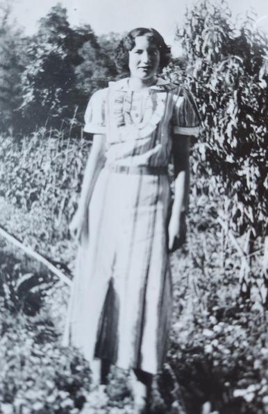 My mother standing outside wearing a dress she made herself. She was just home after leaving Indian Boarding School. A skilled seamstress as she was trained to work as a domestic servant.