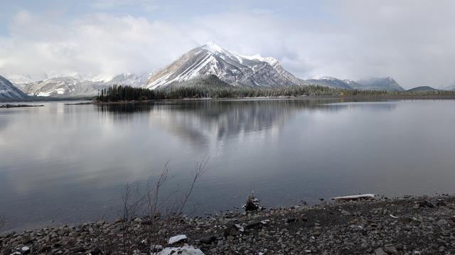 a snowy mountain and it's reflection in a lake