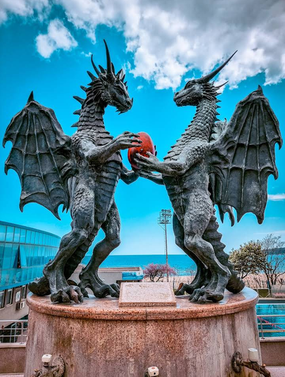 The Dragons In Love statue, with two dragons gazing at each other lovingly and holding an egg between them. This one has its colors boosted a lot, the sky is very blue and the egg is bright red.
