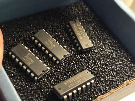 Four ICs on a black antistatic foam mat.