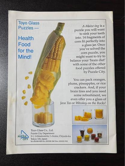The rear cover of Puzzle World Summr 1992 magazine. It shows a cob of corn disintegrating into a small glass in the most horrible way possible.

The copy reads:
A-Maize-ing is a puzzle you will want to sink your teeth
into. 14 fragments of corn fit perfectly intoa glass jar. Once you've solved the corn puzzle, you might want to try to balance your brain diet'
with some of the other food puzzles offered
by Puzzle City. You can pack oranges, plums, pineapples, or rice
crackers. And, if your brain tires and you need some refreshment, we even offer you a glass of Java Tea or Whiskey on the Rocks!