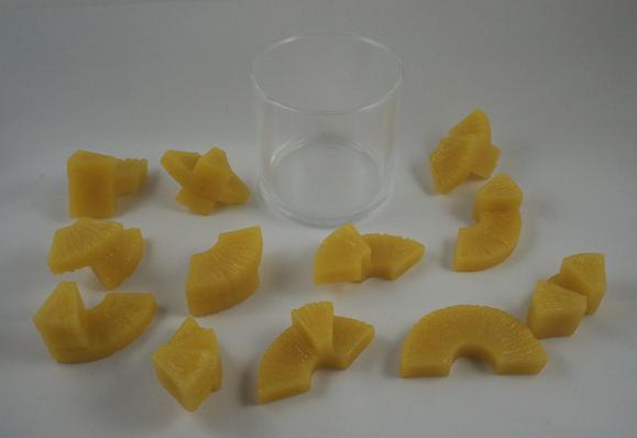 Fake pineapple chunks surround an empty glass.