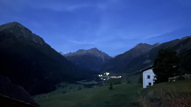 View of the lower Engadine valley before sunrise with the village of Lavin below illuminated by electric lights. The iPhone camera’s Night Mode makes it seem lighter than it appeared to the naked eye.