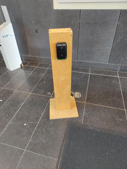 A wooden pillar mounted with an RFID scanner with the text "updater"