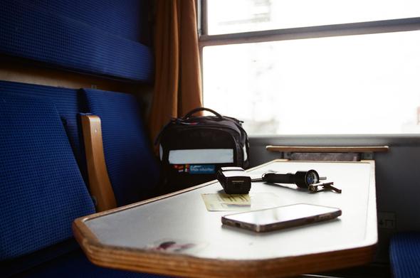 Table in train with backpack lanp radio phone and stickers