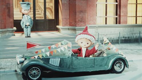 Screenshot from the stopmotion kids tv show Sandman, with the Sandman as santa driving a fancy old car..