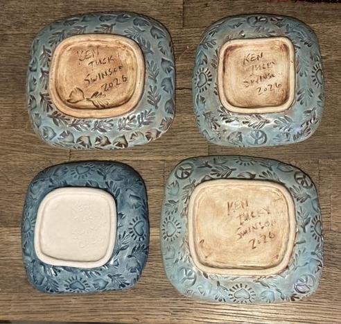 The back of 4 plates, they have texture and are signed by the artist