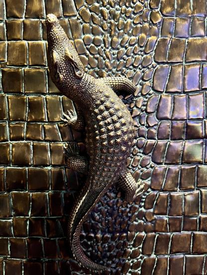 A stylized alligator on a wall made of stylized alligator skin. Pure decoration, no function.