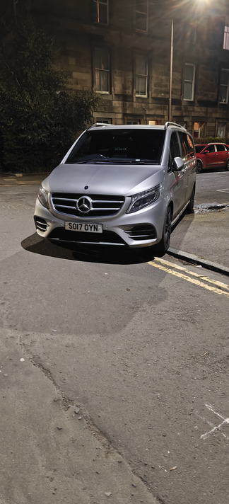 Photo shows a minivan parked across the corner of a junction blocking the dropped curb