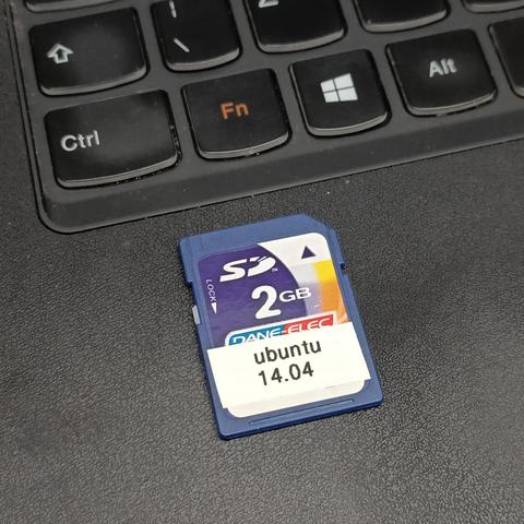 A fairly generic looking full sized SD card that is marked as 2GB. A little sticker from a label printer is stuck on it. The label says "Ubuntu 14.04"