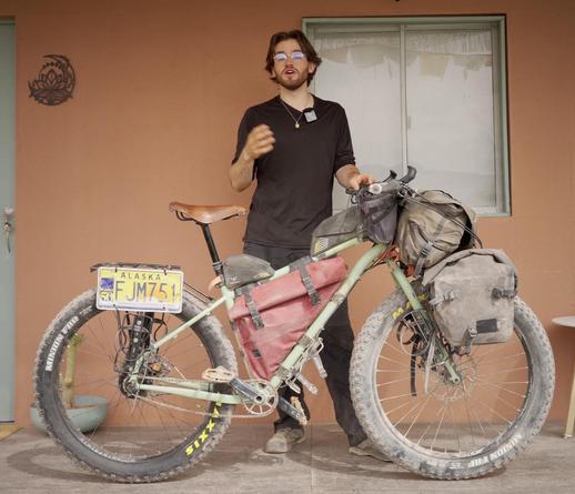 Dan, three years older and miles and miles away from where he started. His currrent bike is another light green one but this is a Tumbleweed prospector with 27.5 wheels and bit 3.8" tires. Panniers are on front rack for weight distribution (water going on back rack), there's a large handlebar bag along with a couple "feed" bags on each side of the inside handlebar. Two top tube bags, front and back, and a large red frame bag. Key point, none of the bags use zippers, they all roll up or have some other mechanism to seal while keeping water out. There's an Alaska license plate on back rack he found around start of journey.