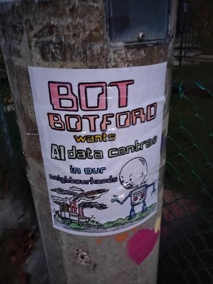 A hand-coloured flyer taped to a lamp pole. It depicts a robot with the head of an angry Caillou next to a factory belching dark smoke from several smokestacks and green sludge from pipes. The flyer reads: Bot Botford wants AI data centres in our neighbourhoods.