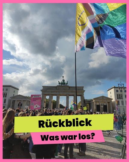 Foto einer Demonstration auf dem Pariser Platz vor dem Brandenburger Tor in Berlin unter leicht bewölktem Himmel. Im Vordergrund weht eine große Progress-Pride-Flagge an einer Stange. Menschenmengen haben sich versammelt. Über dem Bild liegt ein grafischer Textkasten in Neon-Gelb und Rosa mit der Aufschrift: „Rückblick – Was war los?“.