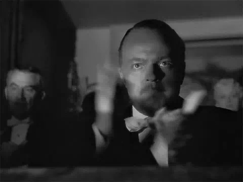 The classic "slow clap" shot from Citizen Kane, with the central character enthusiastically but also angrily clapping with the rest of an audience.