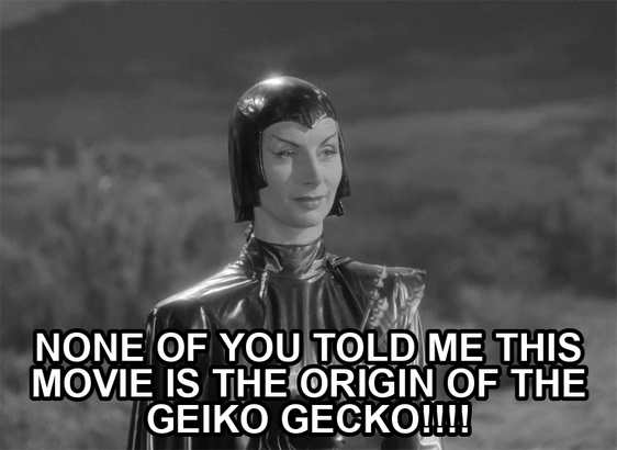 screenshot from the film Devil Girl From Mars showing a serious woman wearing a black leather suit, cape, and cowl. Text reads: "None of you told me this movie is the origin of the Geiko gecko!!!!"