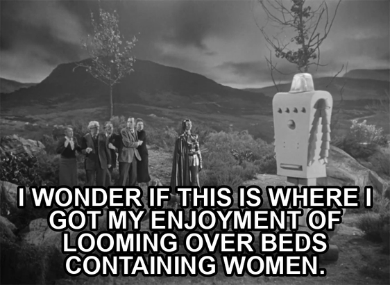screenshot from the film Devil Girl From Mars showing a serious woman wearing a black leather suit, cape, and cowl. Text reads: "I wonder if this is where I got my enjoyment of looming over beds containing women."